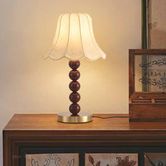 Tischlampe mit Stoffschirm und dekorativer Holzperle